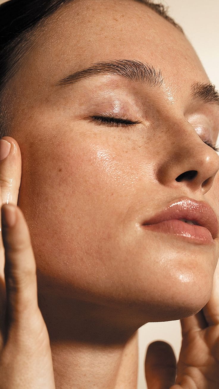 Close-up of a woman applying skincare.