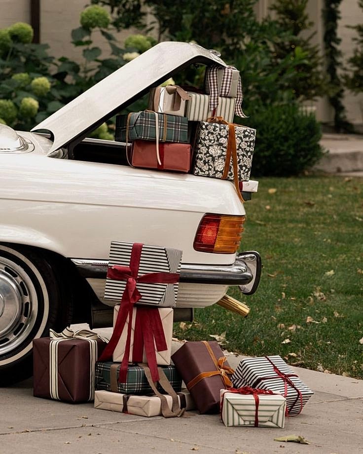 Gifts stacked in a car's open trunk.