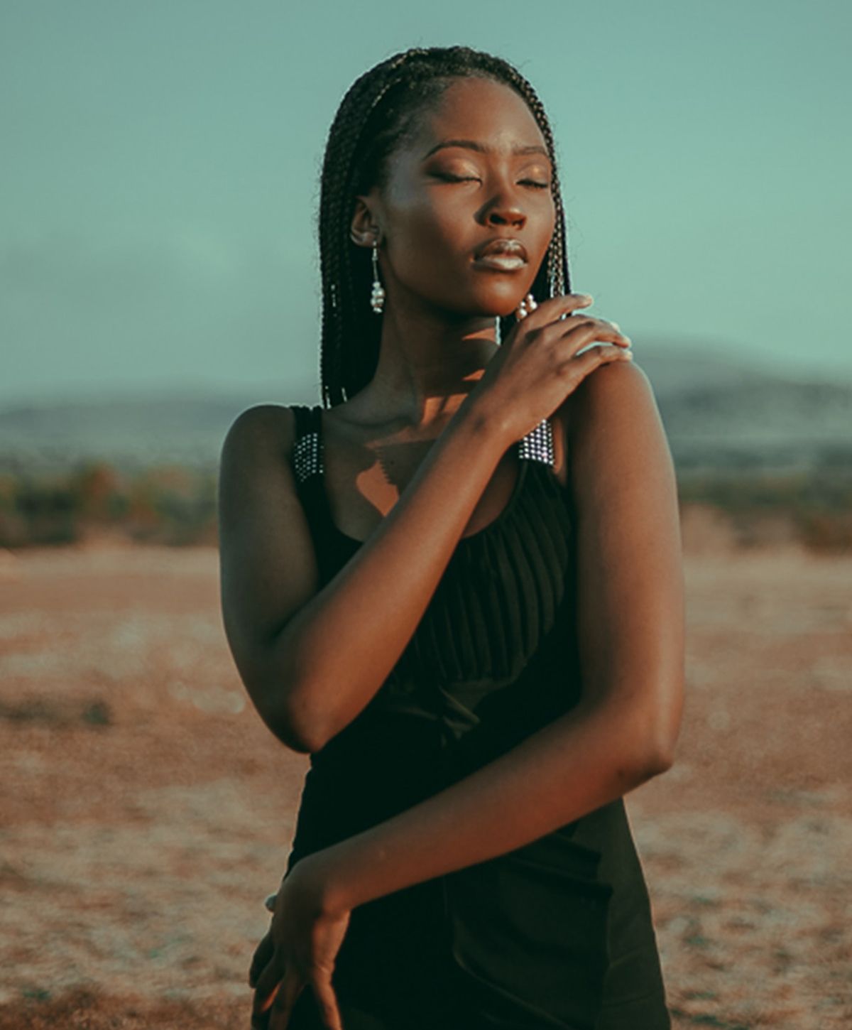 Woman posing gracefully in a natural landscape.