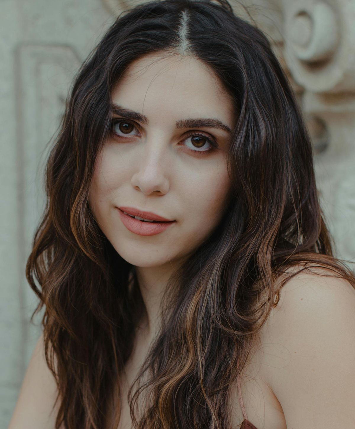 Woman with long, wavy hair and soft features.