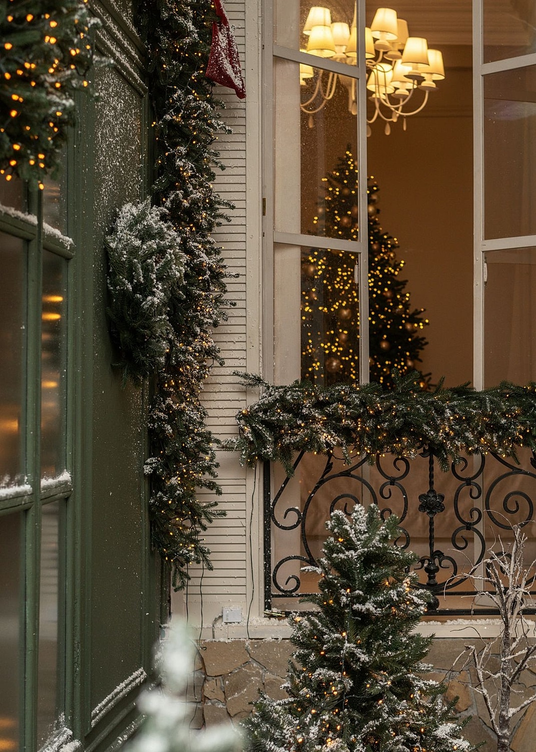 Decorated window with Christmas trees and lights.