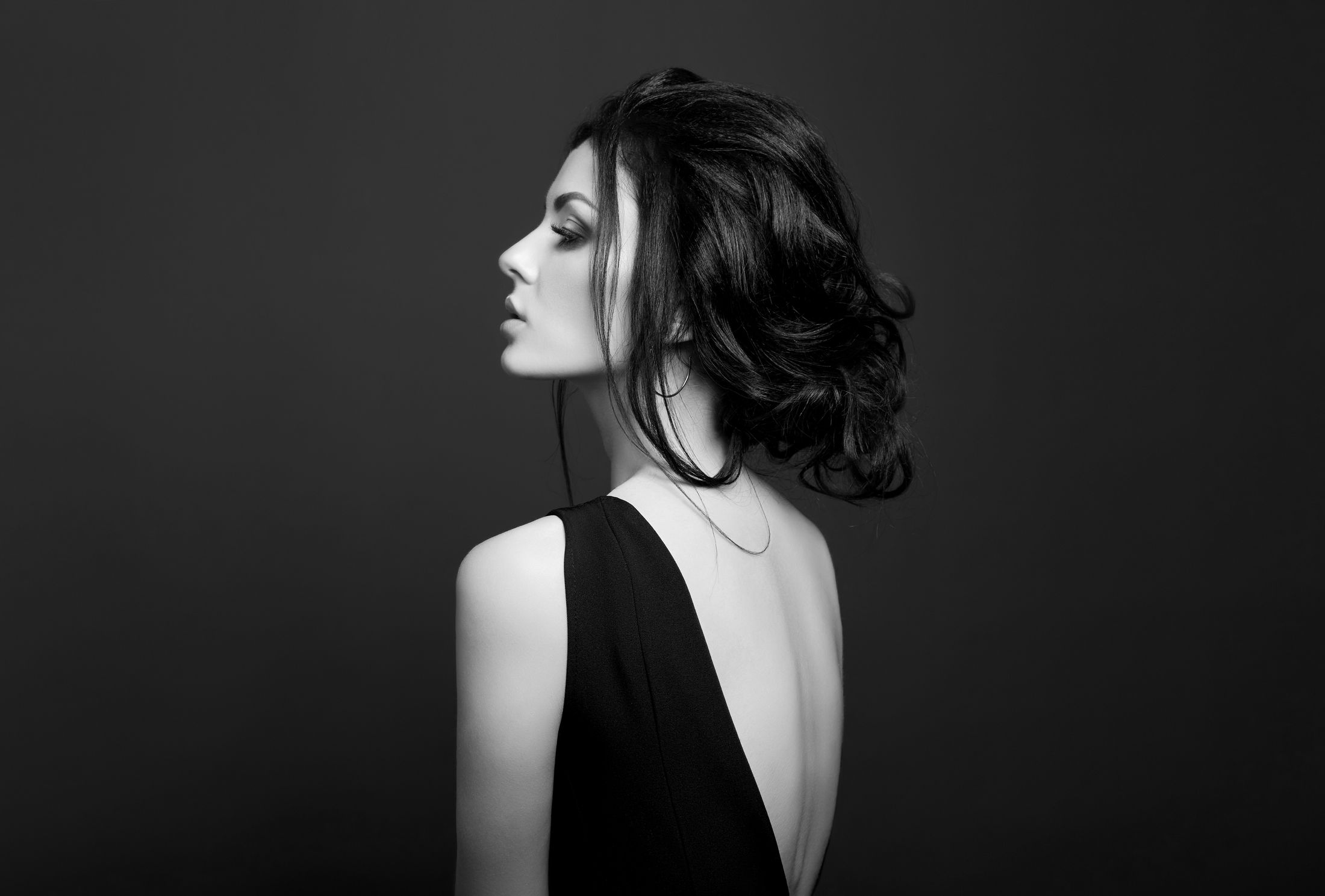 Woman with long hair looking thoughtfully into distance.