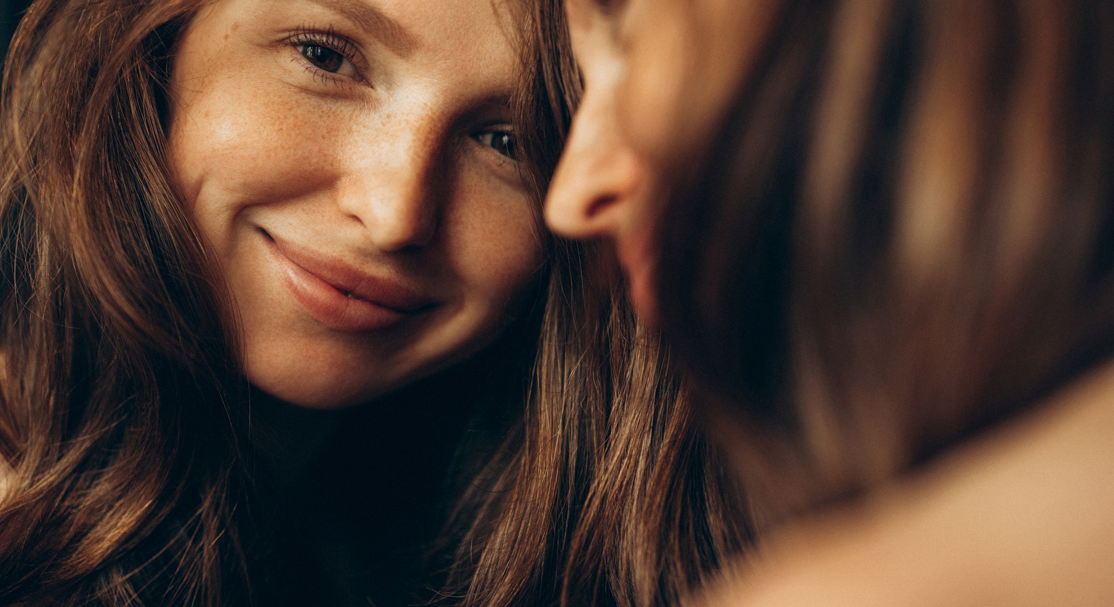 Smiling woman with long, wavy hair close-up.