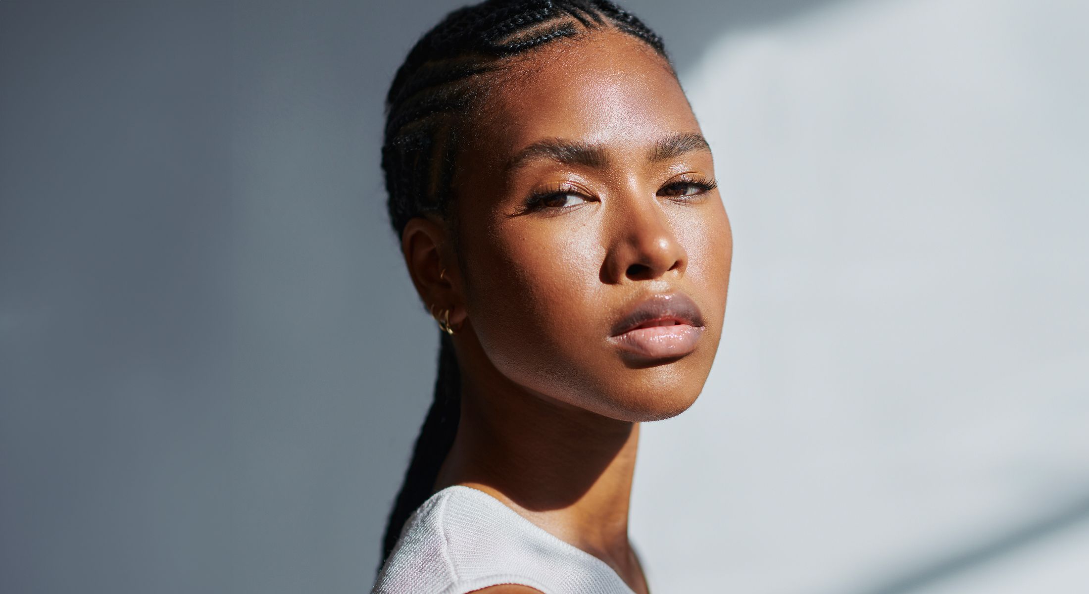 Portrait of a woman with braided hair, serene expression.