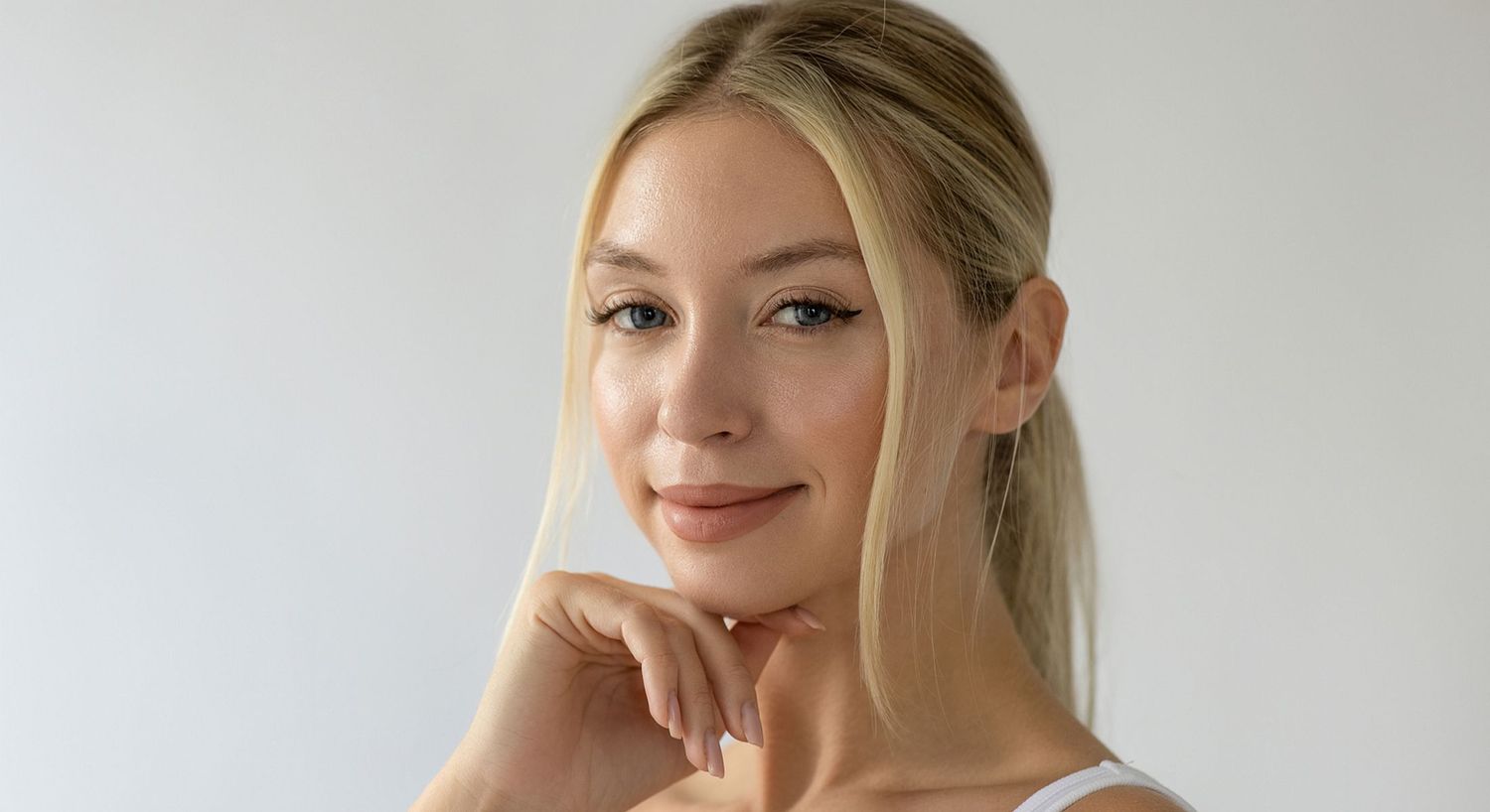 Smiling woman with blonde hair against white background.